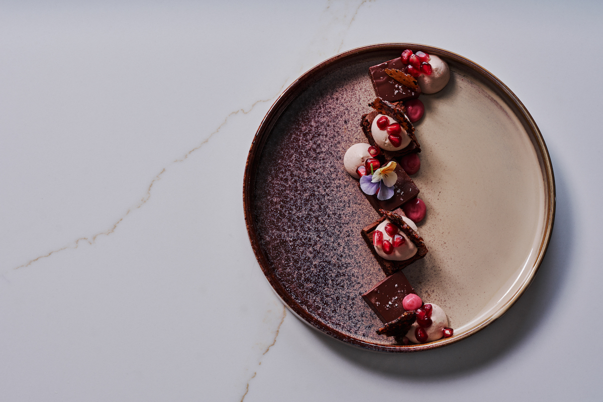 Araguani chocolate - passion fruit ganache - pomegranate - mole crunch - DiningOut At Bar ANA, James Beard-nominated pastry chef Claudia Martínez transforms dessert into edible art with creations inspired by her Venezuelan heritage and Southern roots. | Photo by Bar ANA