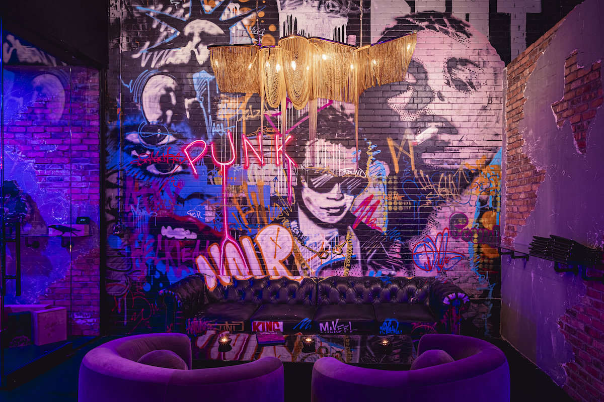 A mural by Dallas artist Michael Shellis anchors the Noir Lounge, where graffiti-inspired artwork and plush seating introduce Punk Noir's edgy "business punk" aesthetic. | Photo by Samantha Marie Photography