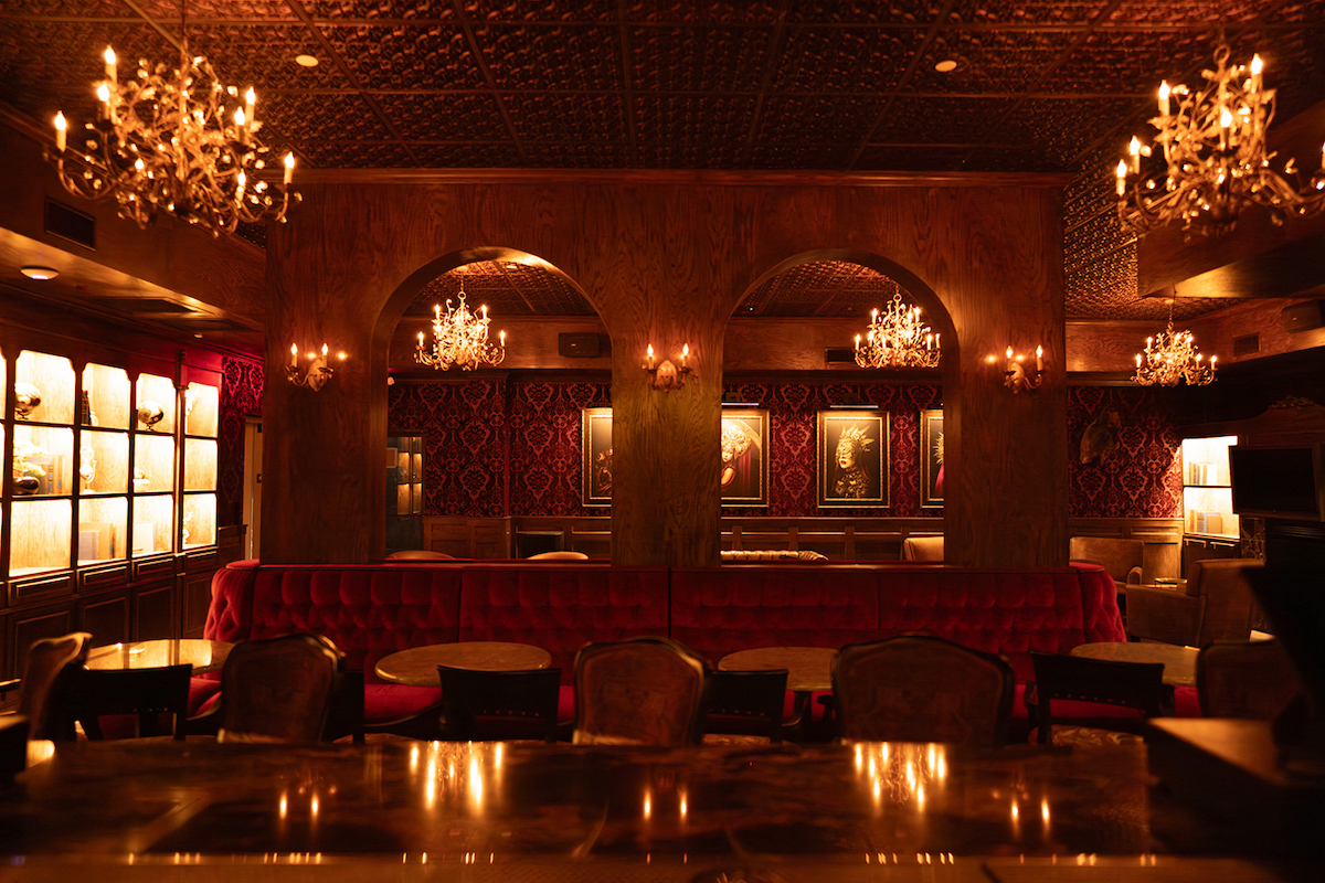 Dark wood paneling, ornate chandeliers, and rich red velvet seating set the stage at Atlas Houston Heights. | Photo by Joseph Rojas