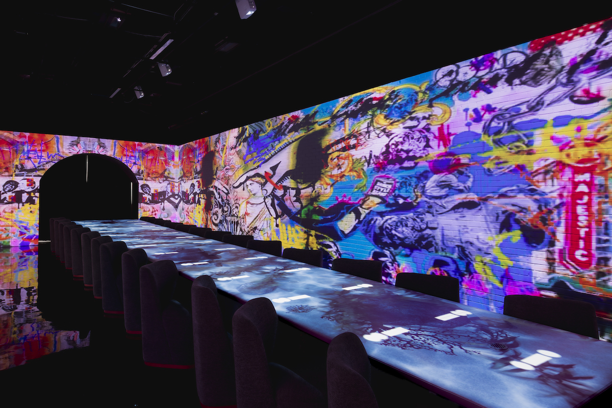Guests begin the Punk Noir experience in a communal dining room where immersive digital projections transform the walls and table throughout the 20-course tasting menu. | Photo by Samantha Marie Photography