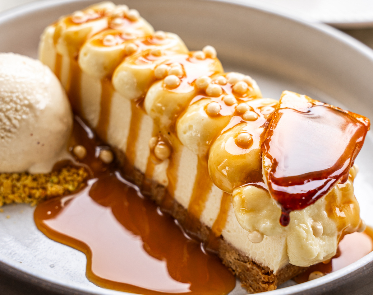 Luella - DiningOut Luella’s Bananas Foster Cheesecake is finished tableside with brown butter caramel and served with spiced ice cream. | Photo by Luella