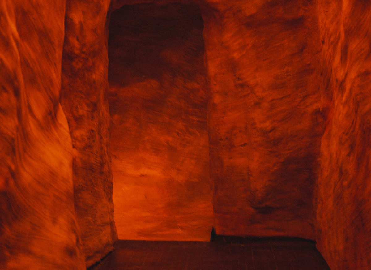 A sculpted, terracotta-hued entry passage sets the stage at La Cueva. | Photo by Lauren Lynn