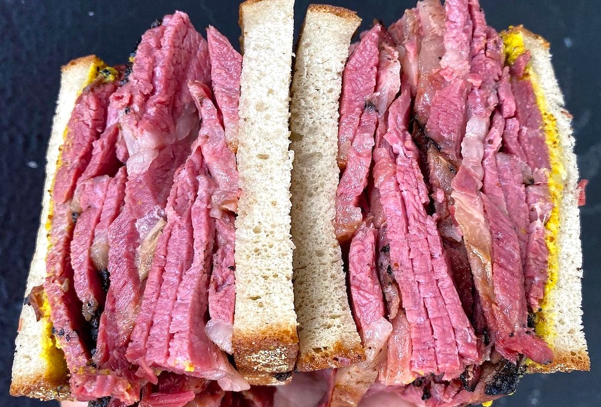 This NYC deli is iconic for its corned beef, pastrami, and Reuben sandwiches. | Photo courtesy of Katz's Delicatessen 