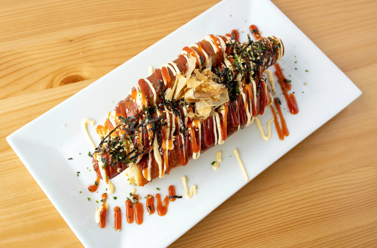 Okaeri Cafe's Okonomi Doggu puts a Japanese spin on the classic hot dog with bonito flakes, nori, furikake, Japanese mayo, and ketchup for a bold umami-packed bite. | Photo by Okaeri Cafe
