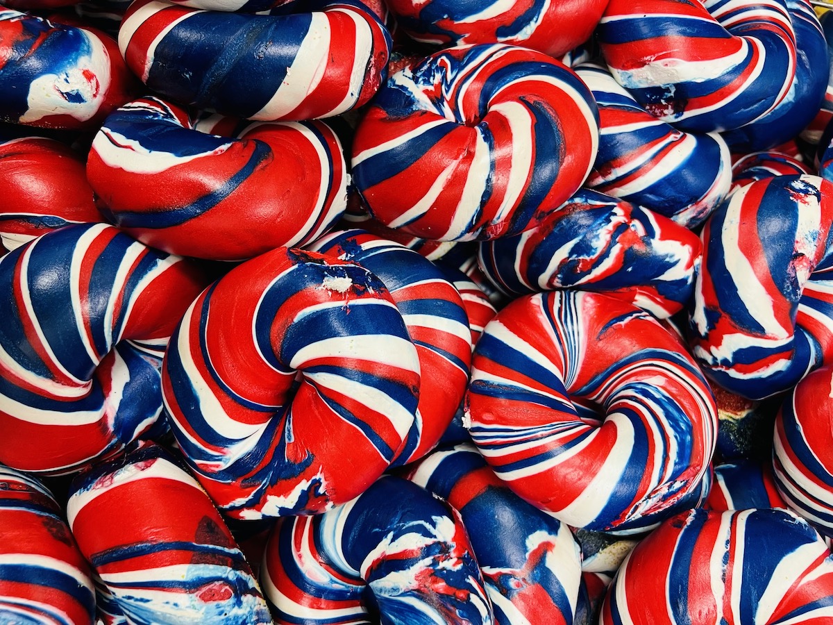 New York Deli and Bagel Shop Bakery - DiningOut Red, white, and blue plain bagels at New York Deli and Bagel Shop Bakery. | Photo by New York Deli and Bagel Shop Bakery