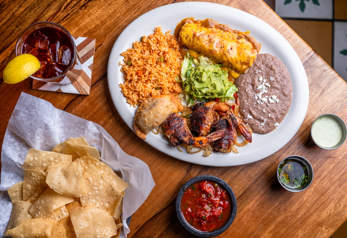 A Tex-Mex feast at Escalante's worth gathering around—grilled shrimp, cheese enchiladas, Mexican rice, refried beans, fresh guacamole, and a crispy empanada, all served with warm chips and house salsa. | Photo by Escalante's