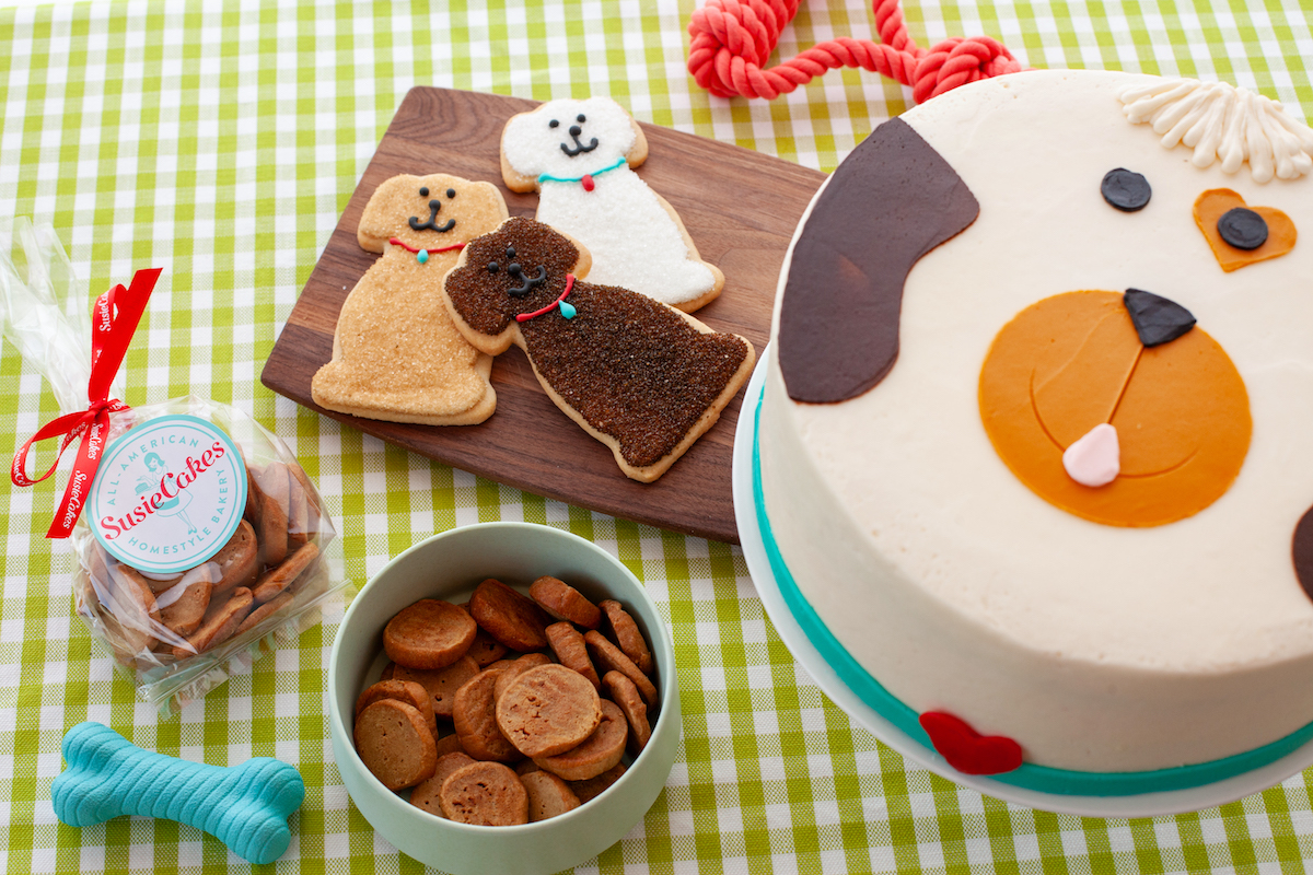 SusieCakes' Dog Days of Summer collection features dog-shaped Frosted Sugar Cookies, homemade dog treats, PupCakes, and a festive Dog Decorated Cake, with select purchases benefiting local animal shelters throughout August. | Photo by SusieCakes