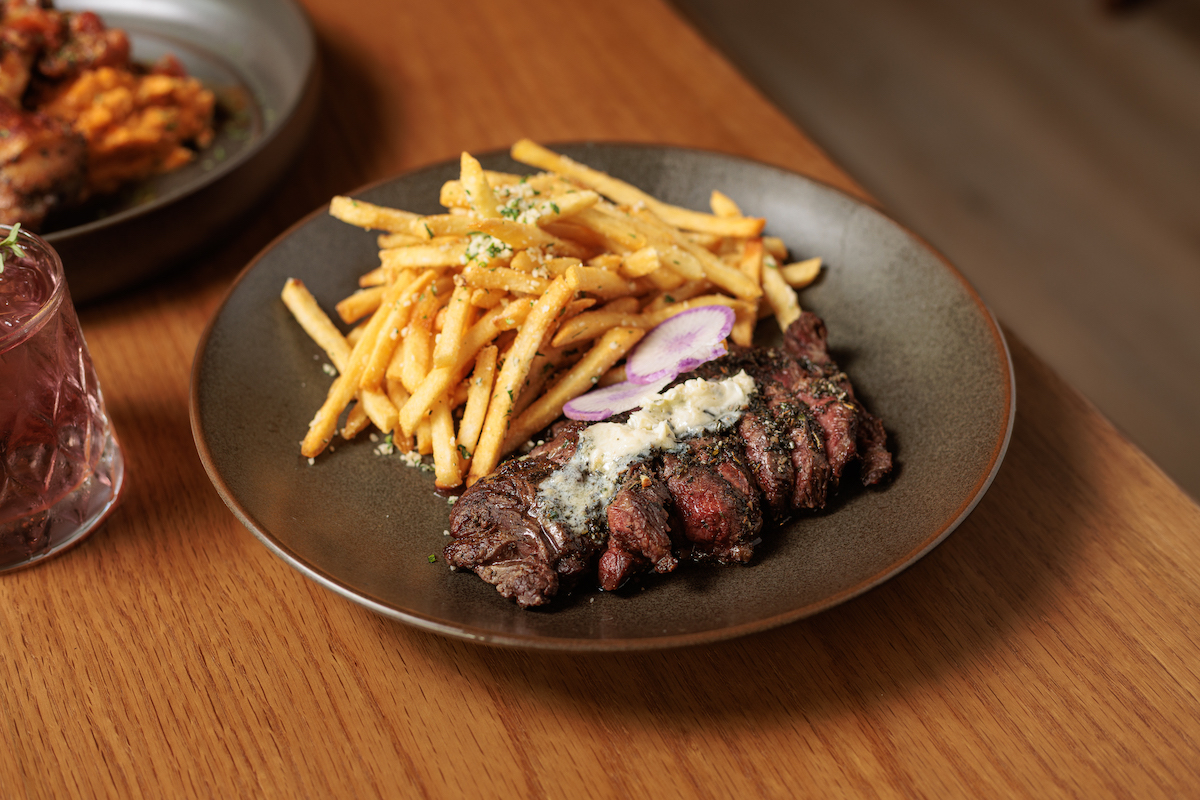 Field & Vine's steak frites pairs grilled steak with crispy Parmesan fries, highlighting the restaurant's chef-driven approach to approachable classics. | Photo by Dan Padgett