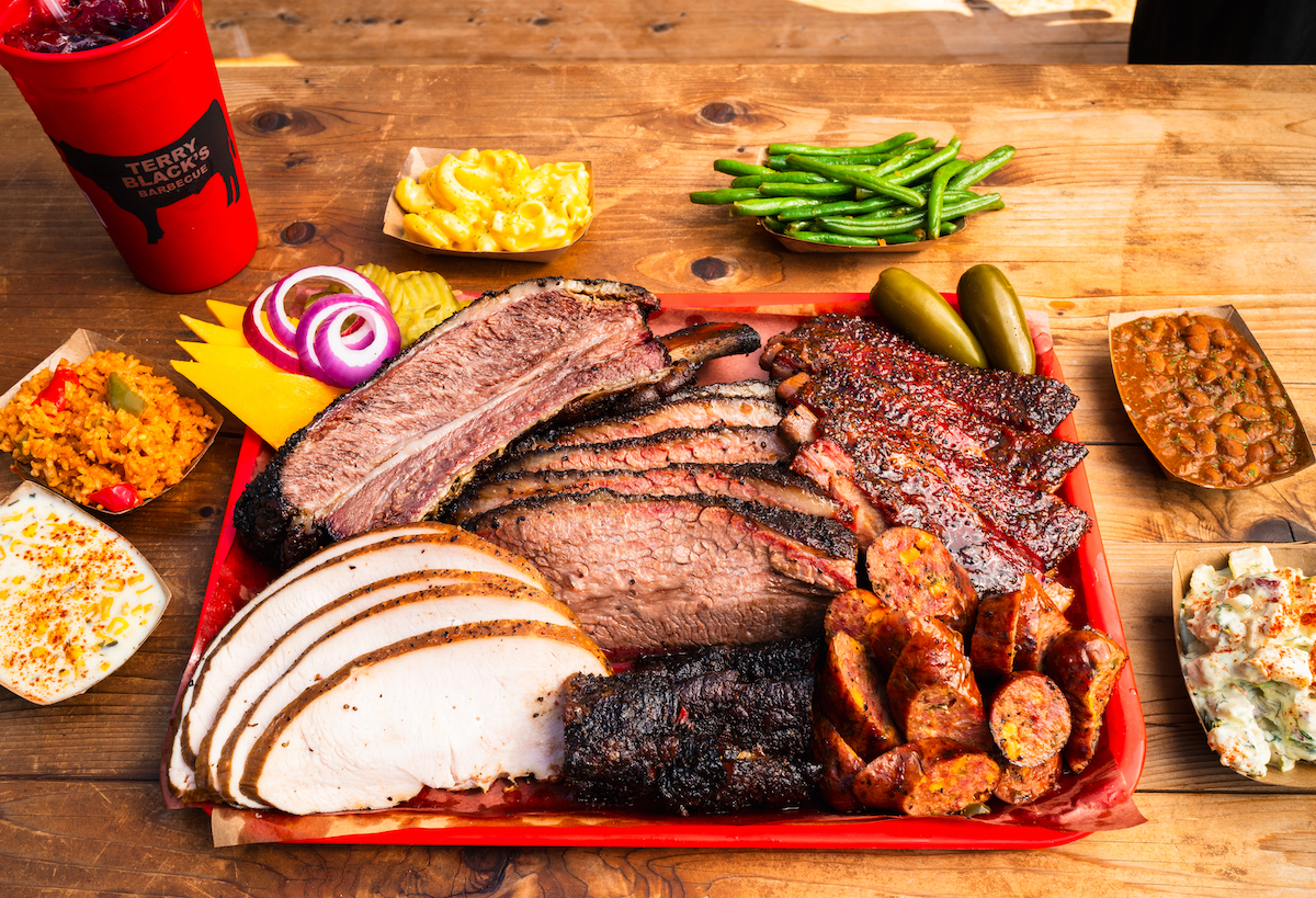 Terry Black's Barbecue has launched the new Terry Black's Experience at its Deep Ellum location, giving guests behind-the-scenes access to the pits before a VIP feast of brisket, beef ribs, pork ribs, house-made sausage, smoked turkey, classic sides, dessert, and a beverage. | Photo by Terry Black’s Barbecue