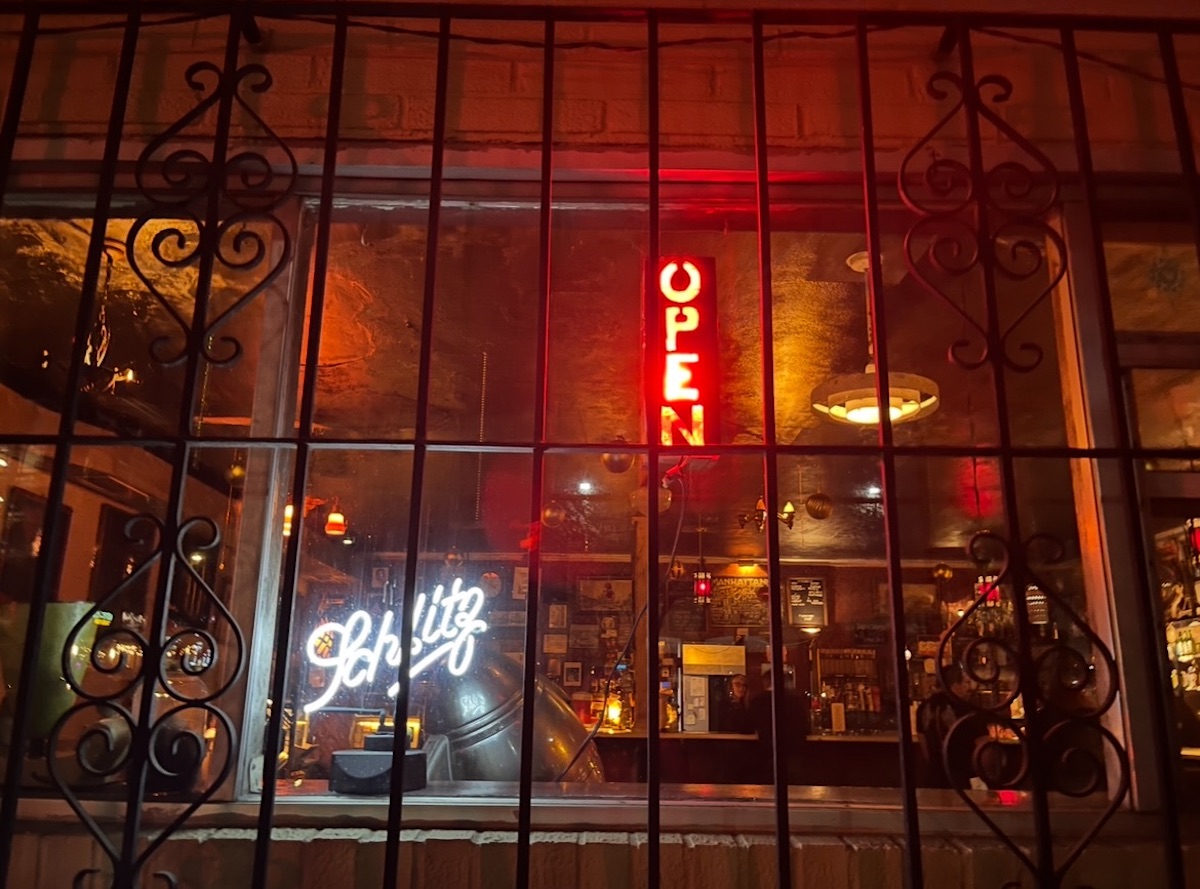 Manhattan Cafes Bar-Covered Facade - DiningOut Behind its barred windows, Manhattan Cafe embraces its quirky personality with eclectic décor, a loyal crowd of regulars, and one of Athens' most distinctive dive bar atmospheres.| Photo by Manhattan Cafe