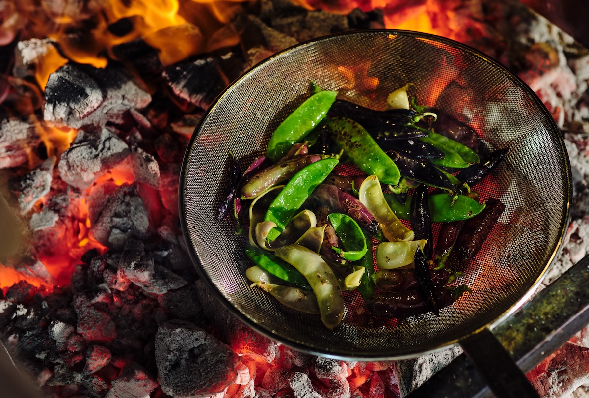 Pimientos cooking on a live fire at Graciela. | Photo by Nico Schinco