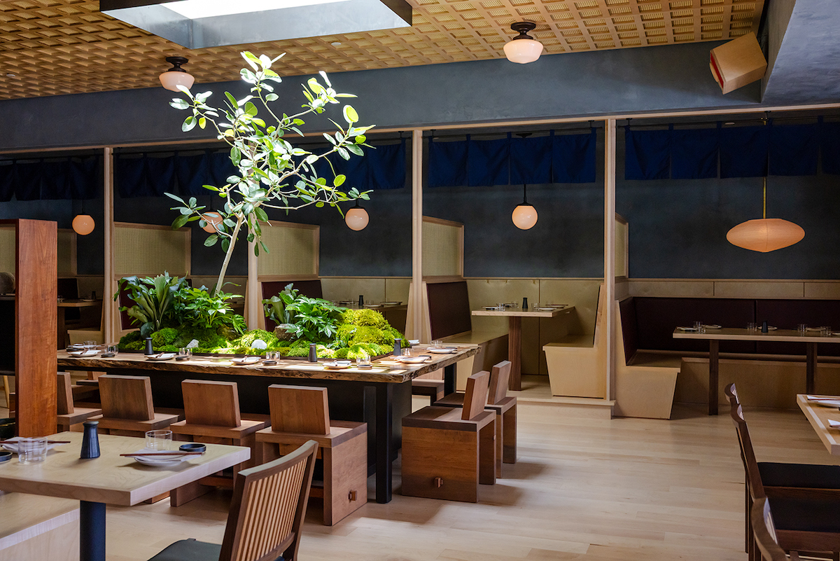 Natural light pours through a skylight onto Neighborhood Sushi's signature communal table, the centerpiece of the warm, wood-clad dining room. | Photo by Justin Cook