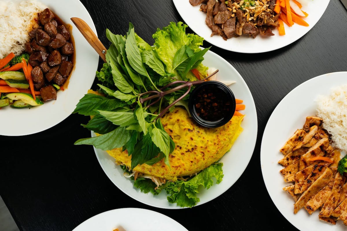 Papaya Kitchen's crispy bánh xèo is served with fresh herbs, lettuce, pickled vegetables, and house-made fish sauce for wrapping and dipping the traditional Vietnamese way. | Photo by Papaya Kitchen