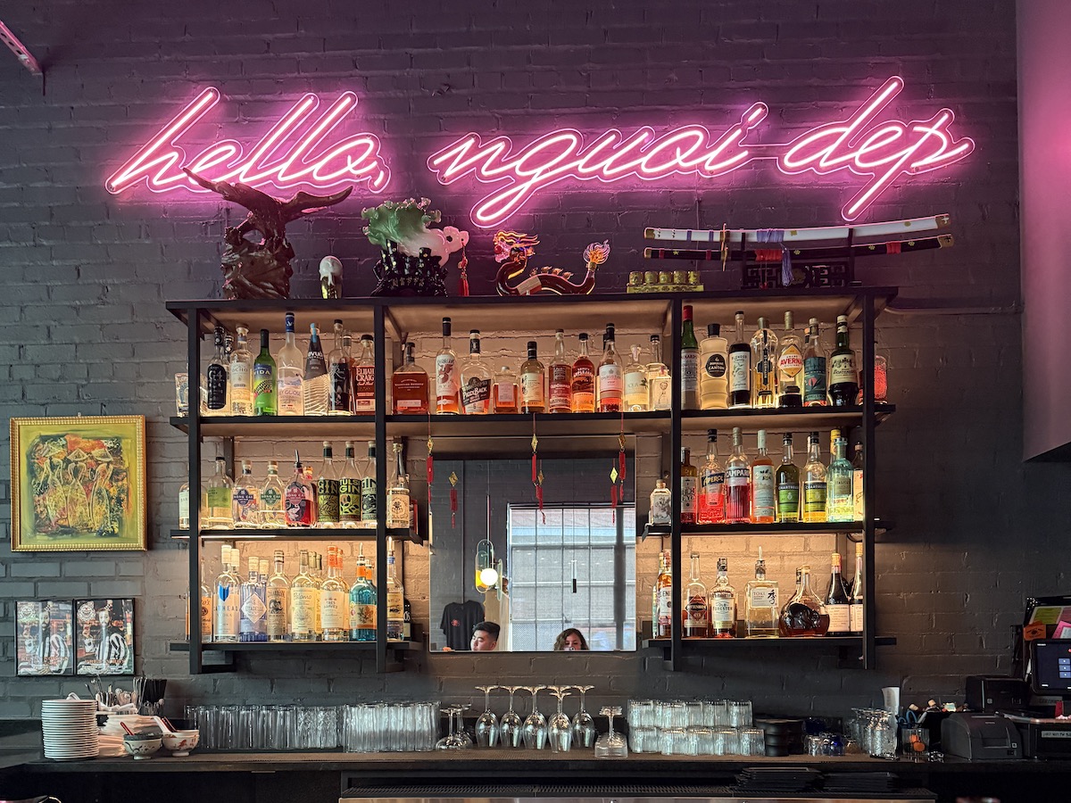 Pretty Boy - DiningOut The bar at Pretty Boy pairs Vietnamese-inspired cocktails with a vibrant atmosphere beneath the restaurant's signature pink neon sign. | Photo by Sarah Bisacca