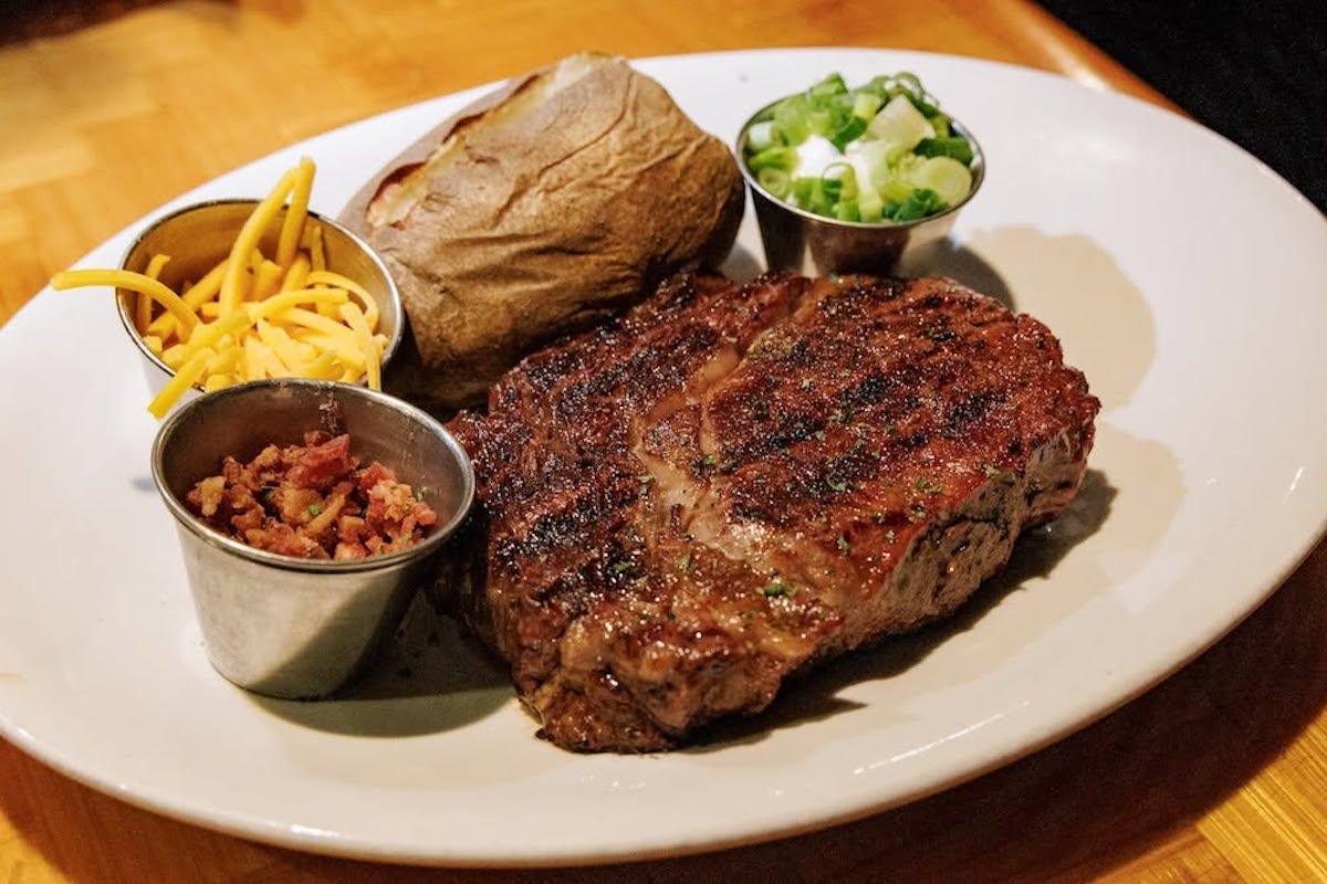 A Certified Angus Beef ribeye with a baked potato and salad bar showcases the timeless menu that has kept diners returning to The Peddler for 50 years. | Photo by the Peddler Steakhouse