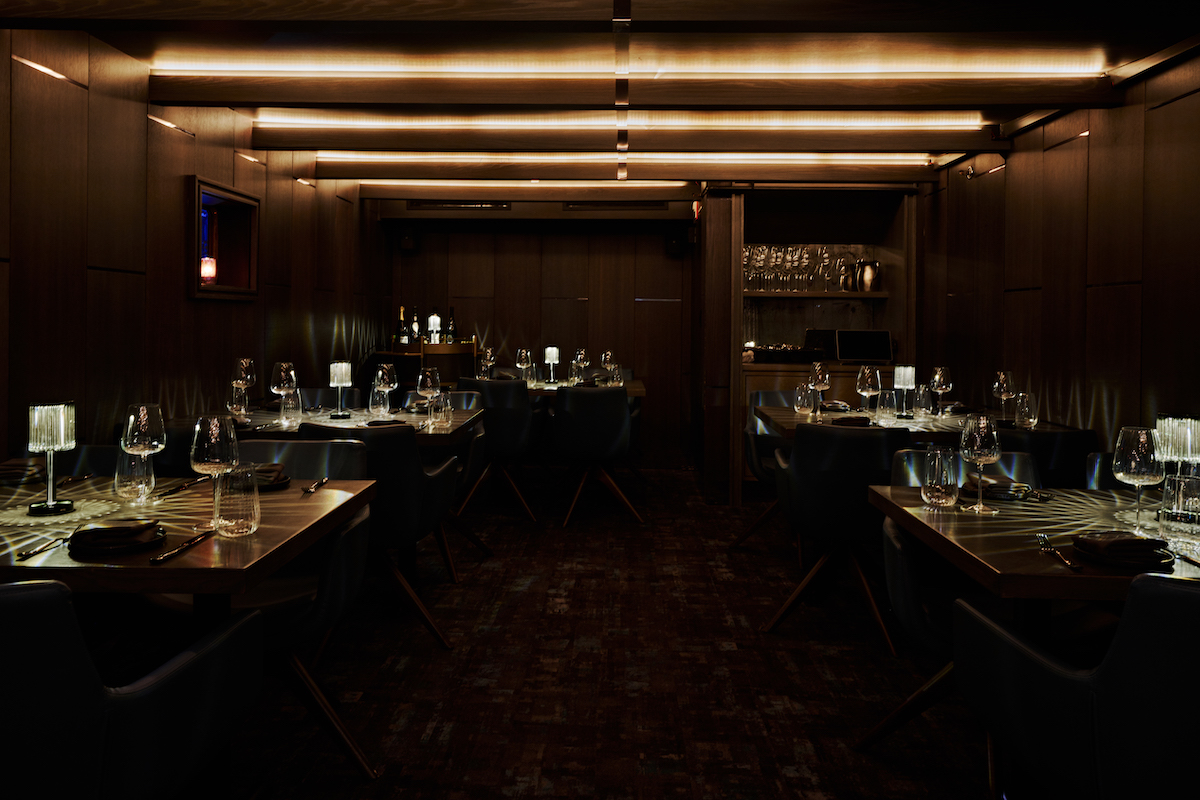 Siren’s moody, low-lit dining room channels the sea caves of the Italian coast with dark wood, intimate seating, and dramatic lighting. | Photo by Andrew Thomas Lee