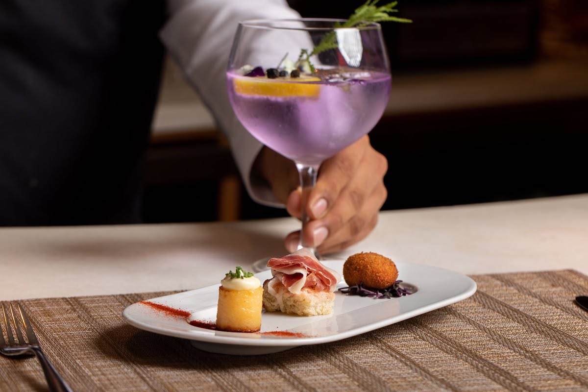 A signature gin and tonic accompanies a trio of small bites at the bar at BCN. | Photo by BCN Taste and Tradition