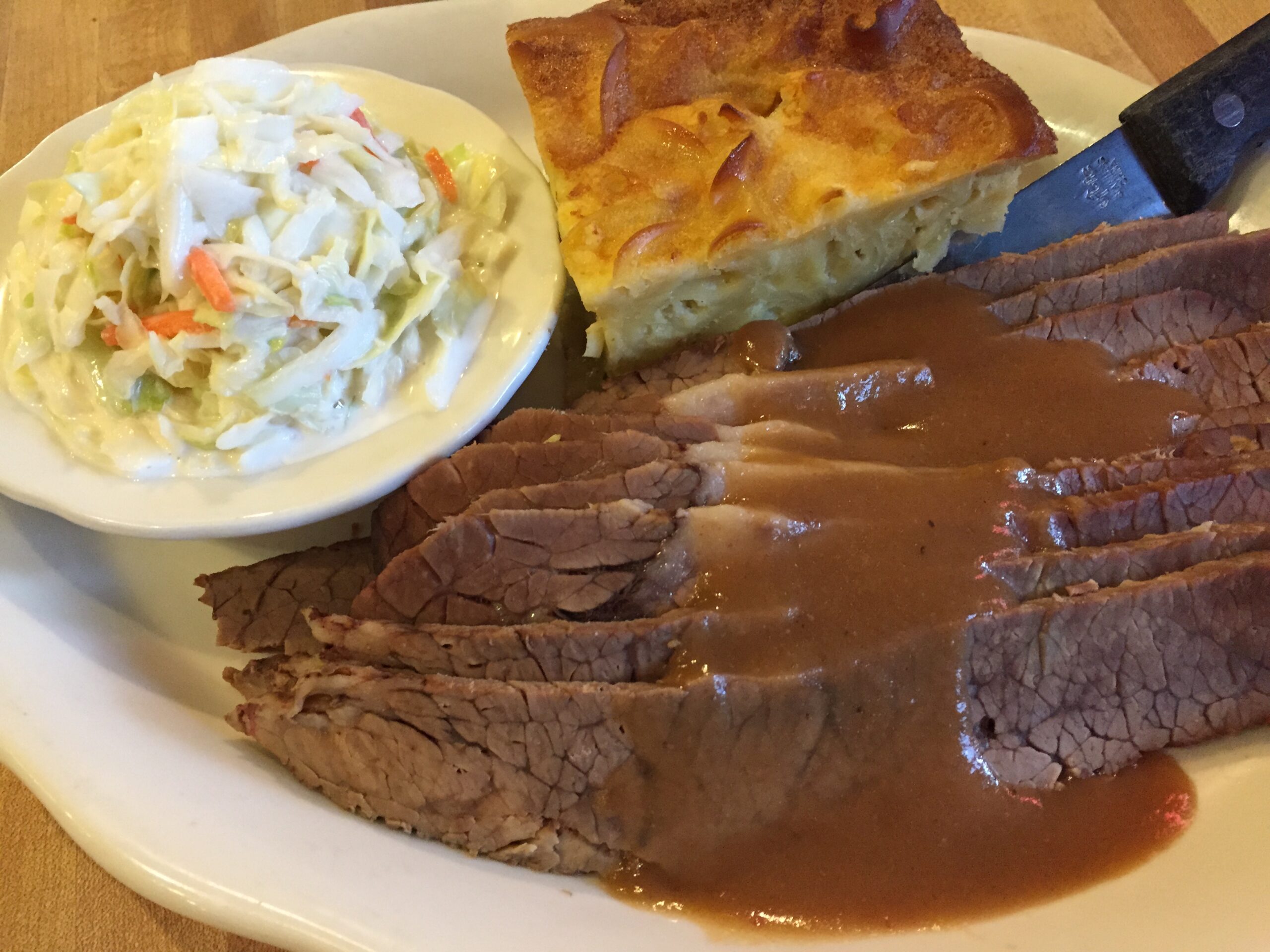 Kenny & Ziggy’s brisket dinner pairs tender, gravy-topped beef with coleslaw and a generous slice of noodle kugel. | Photo by Kenny & Ziggy's
