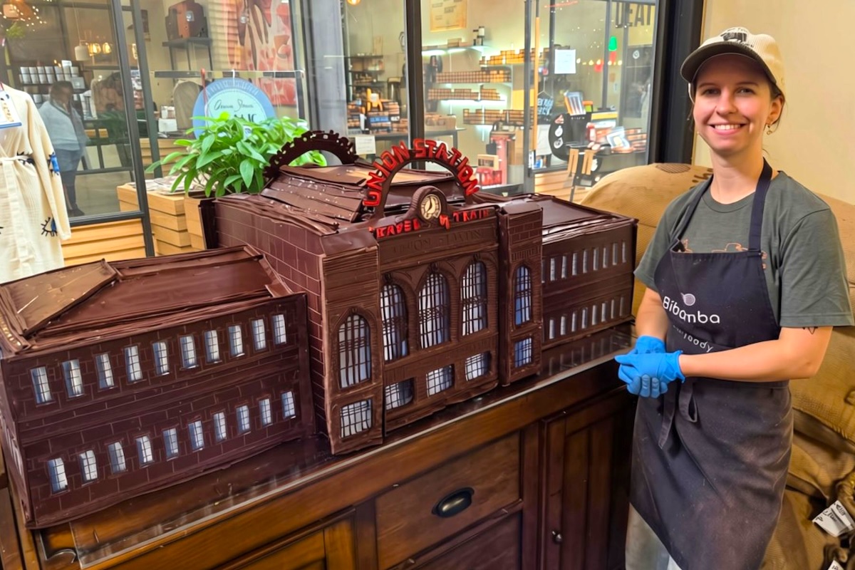 Confectioner Avery Lankford showing off the giant chocolate sculpture of Denver Union Station. | Photo courtesy of Bibamba Artisan Chocolate