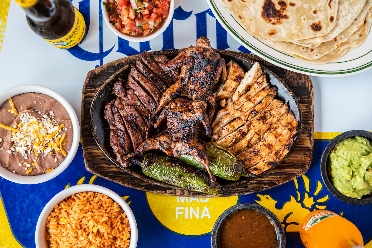 Goode Co. Taqueria goes big with a mixed grill of beef and chicken fajitas alongside tortillas, guacamole, rice, beans, and roasted peppers. | Photo by Jody Hoton