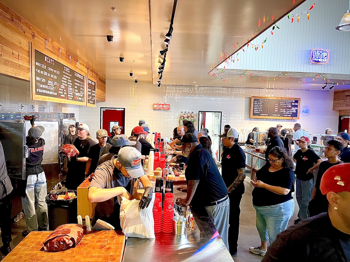 Guests make their way through the line at Terry Black’s Barbecue, choosing smoked meats and sides as their trays take shape. | Photo by Greg Morago