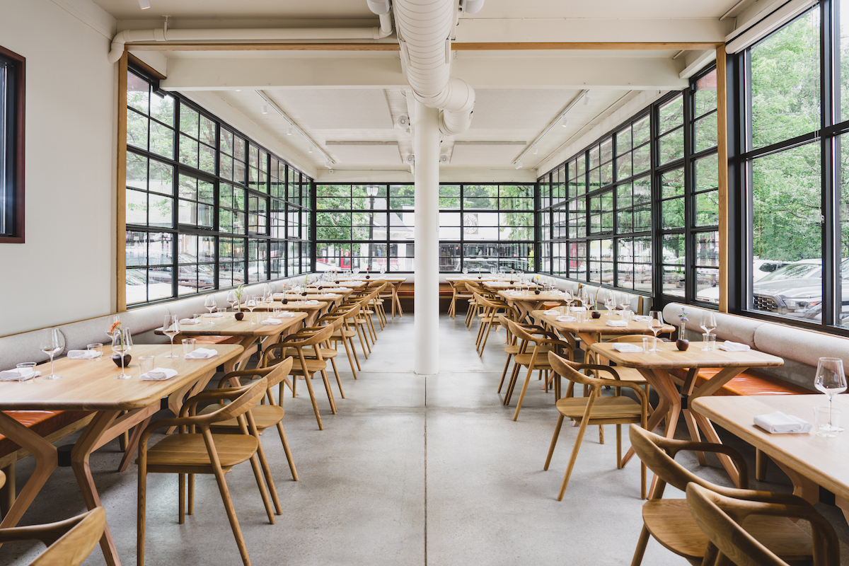 Floor-to-ceiling windows and warm wood furnishings give So. Fox’s Virginia-Highland dining room a bright, understated feel. | Photo by Dave Crawford