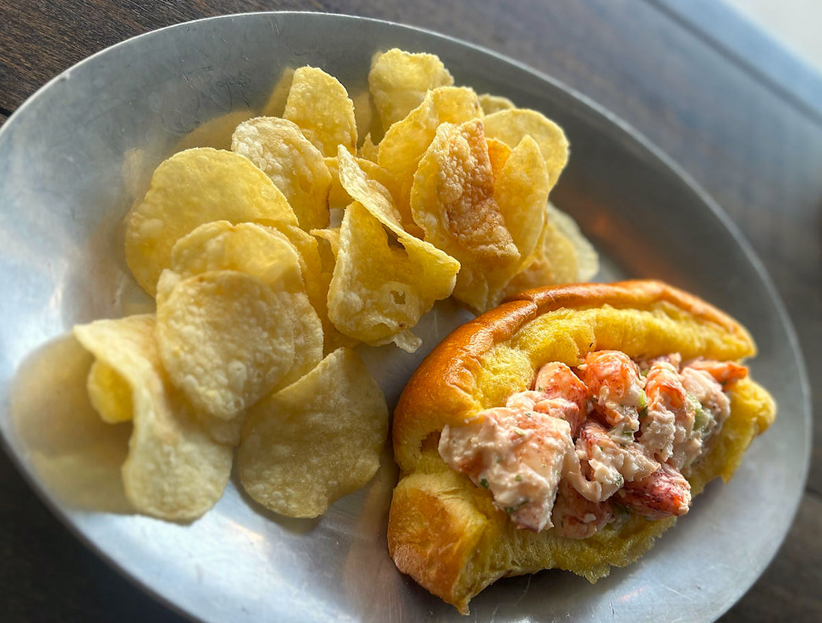 Kathleens Catch Lobster Roll credit_ Kathleens Catch - DiningOut Kathleen's Catch serves a classic Maine-style lobster roll to go, featuring chilled lobster lightly dressed with mayo and paired with kettle chips. | Photo by Kathleen's Catch
