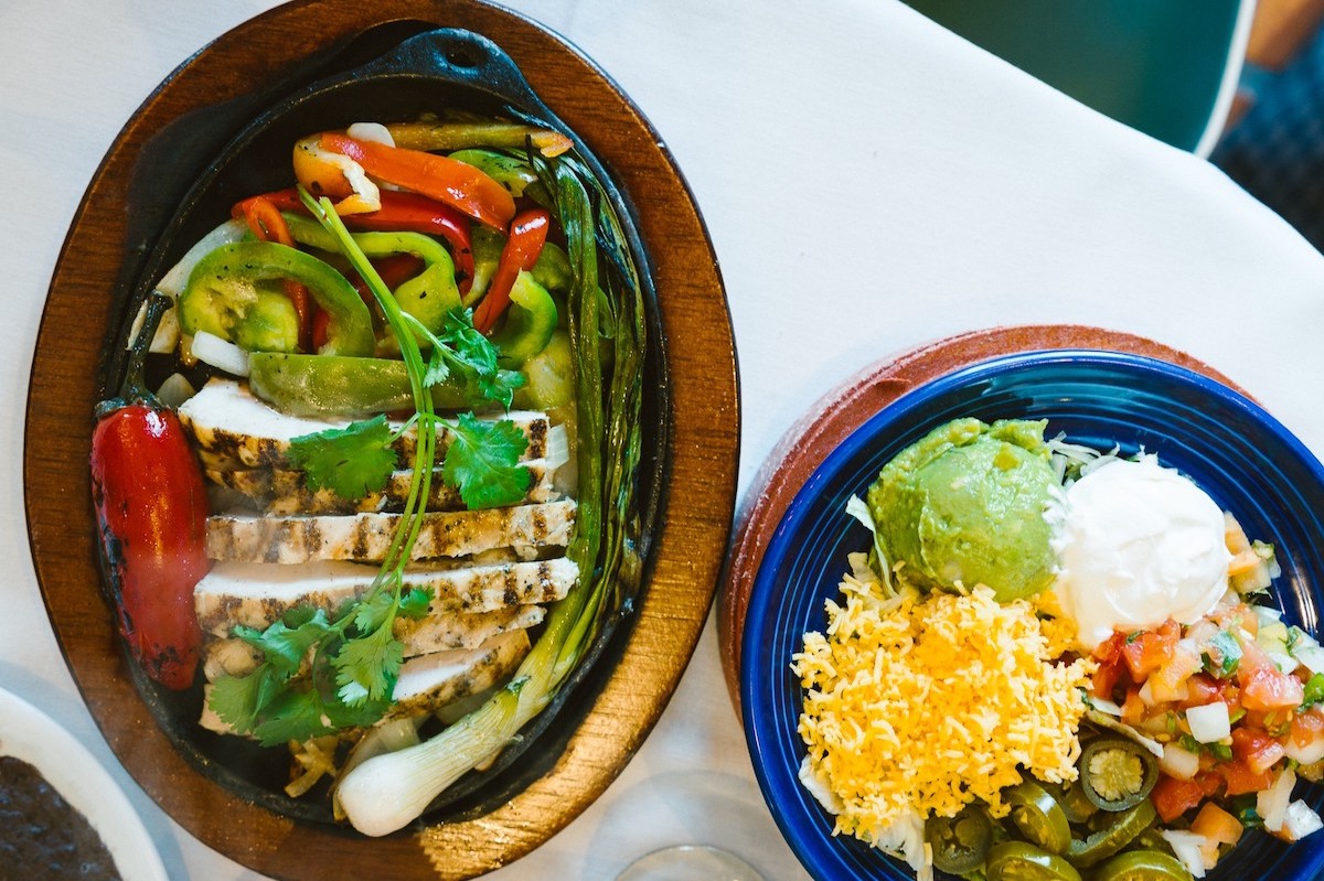 Chicken fajitas arrive sizzling with grilled peppers and onions at longtime Houston Tex-Mex favorite Los Tios. | Photo by Los Tios