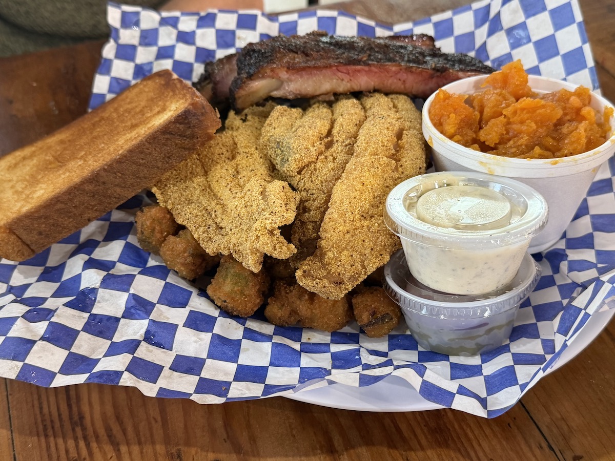 The “Steve White,” a longtime secret-menu favorite, pairs fried-to-order catfish with smoked ribs and Southern sides at Smokey John’s. | Photo by Steven Lindsey