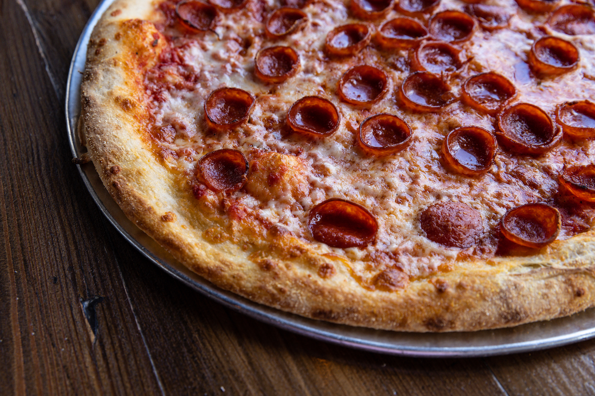 Pizaro's Pizza is offering a limited-time buy-one, get-one-half-off deal on New York-style pizzas through August 27. | Photo by Pizaro's Pizza
