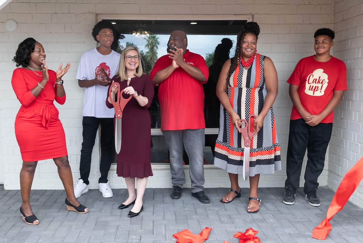 Myesha Harris holds the scissors on the right during a ribbon-cutting outside Red Velvet Recipes. | Photo Courtesy of Red Velvet Recipes