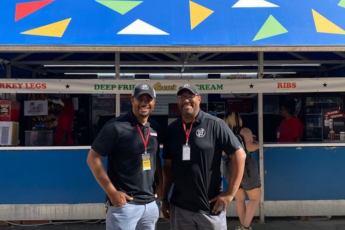 Brothers Brent and Juan Reaves at the Smokey John’s booth at the State Fair of Texas, where the family has been serving fairgoers for decades. | Photo by Smokey John's BBQ