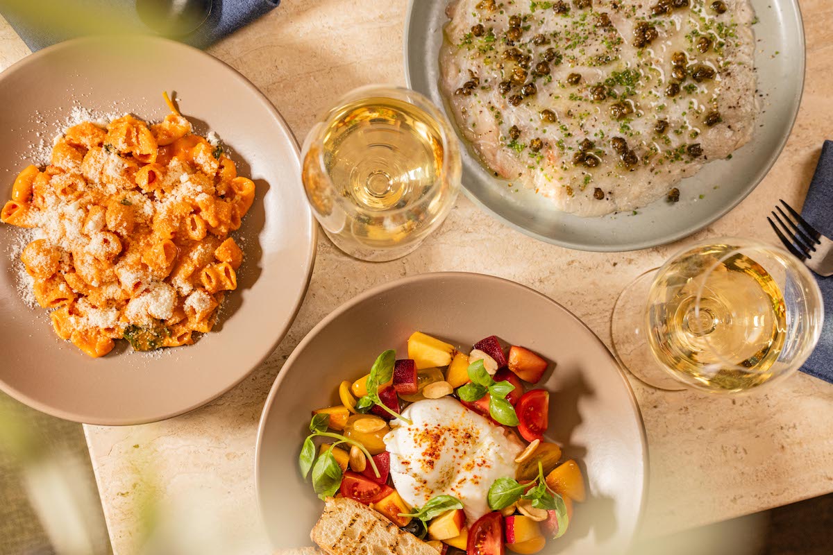 A spread at Élephante Dallas showcases the restaurant’s coastal Italian approach, with pasta, burrata, seafood, and wine meant for sharing. | Photo by Élephante