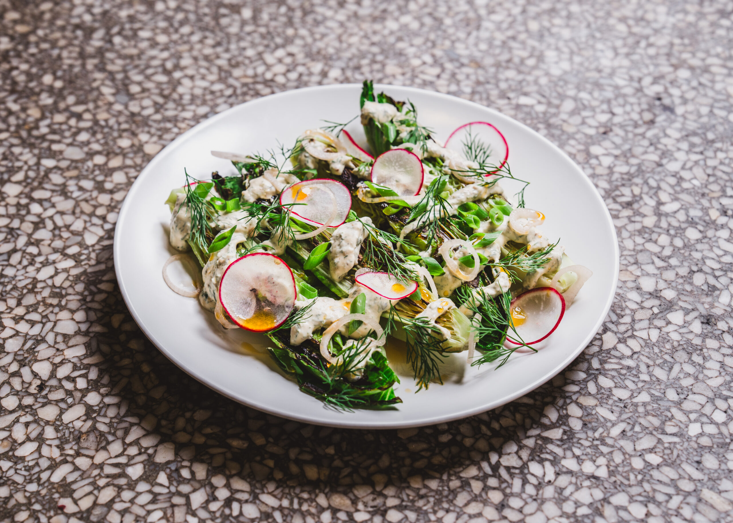 Tender greens are dressed simply with fresh herbs, radishes, and dressing. | Photo by Dave Crawford