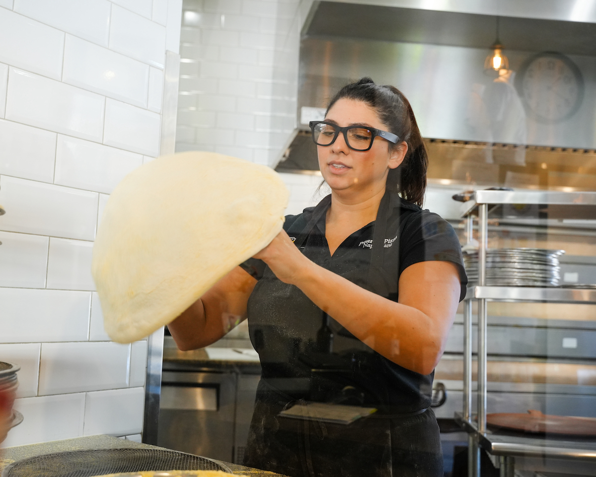 Pizaro’s co-owner Nicole Bean tosses pizza dough at the family-owned Houston pizzeria. | Photo by Sergio Trevino
