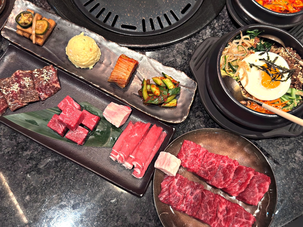 Traditional Traditional Korean Bibimbap with Fried Egg and Assorted Vegetables Served with Raw Beef for BBQ.Korean Bibimbap with Fried Egg and Assorted Vegetables Served with Raw Beef for BBQ. High quality photo denver