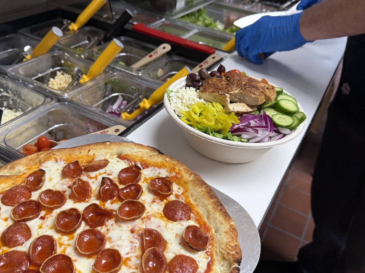 A pepperoni pizza and Greek salad topped with grilled-to-order antibiotic-free chicken showcase the affordable menu at Angie’s new Irving location. | Photo by Angie's
