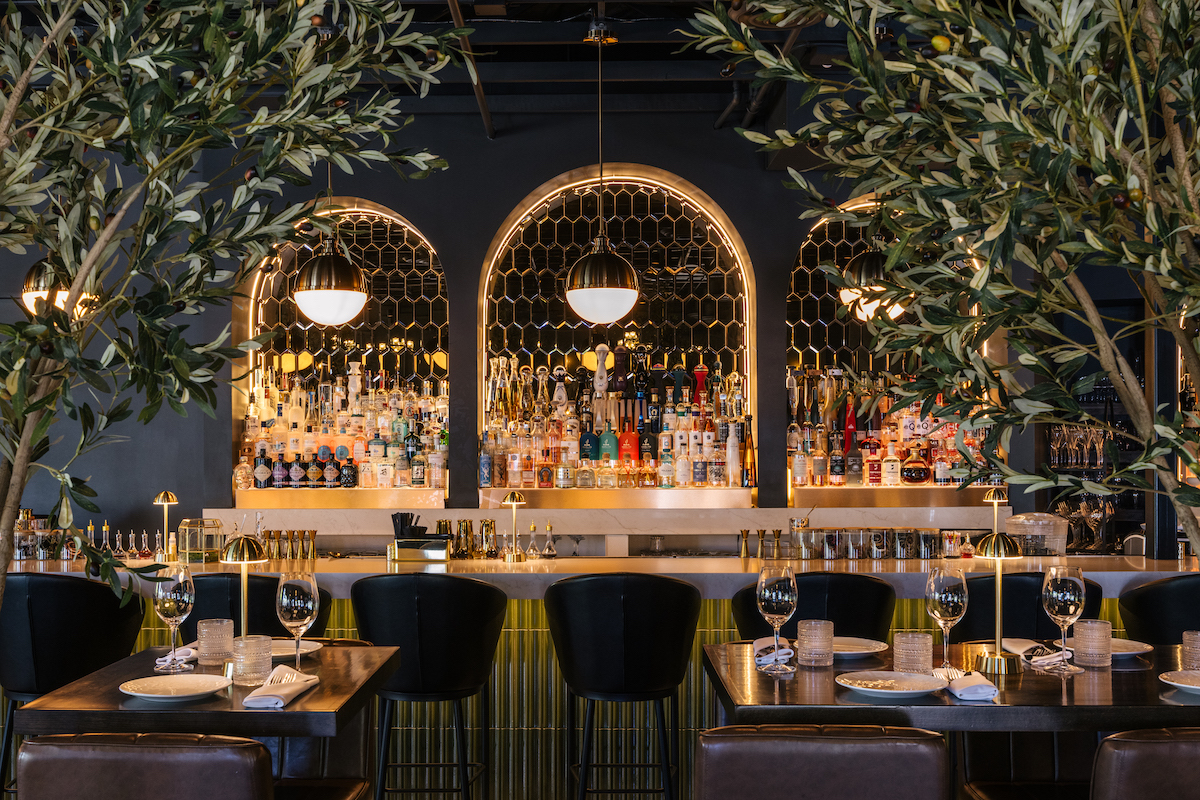 Belmont Kitchen - DiningOut Olive trees and glowing arched displays frame the stylish bar at Belmont Kitchen & Cocktails, which launches its Lunch & Learn series this weekend. | Photo by Belmont Kitchen