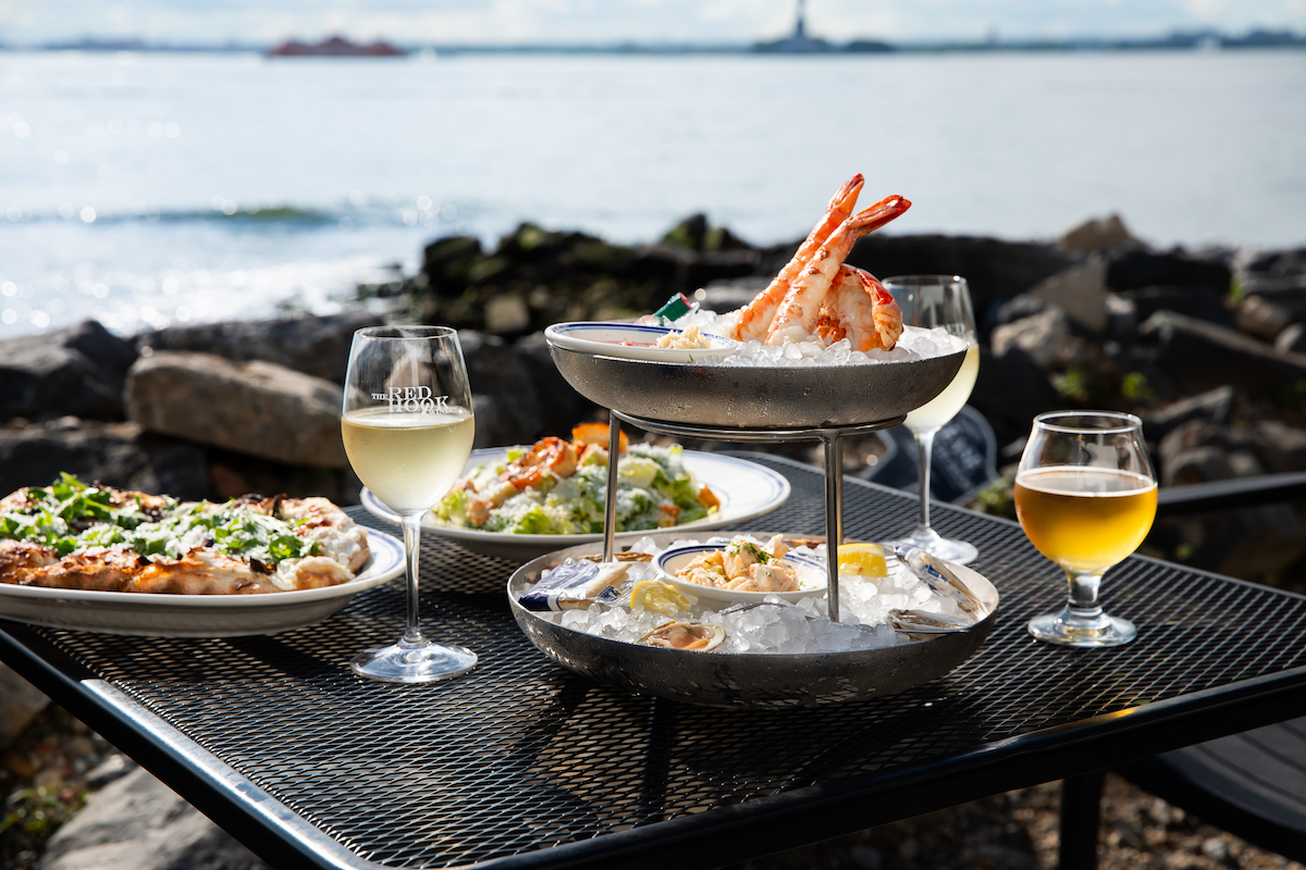 Red Hook Barrel Yard NYC - DiningOut Mushroom pinsa Romana, Caesar salad, and a seafood tower make for a waterfront feast at Red Hook Barrel Yard. | Photo by Lizzie Munro