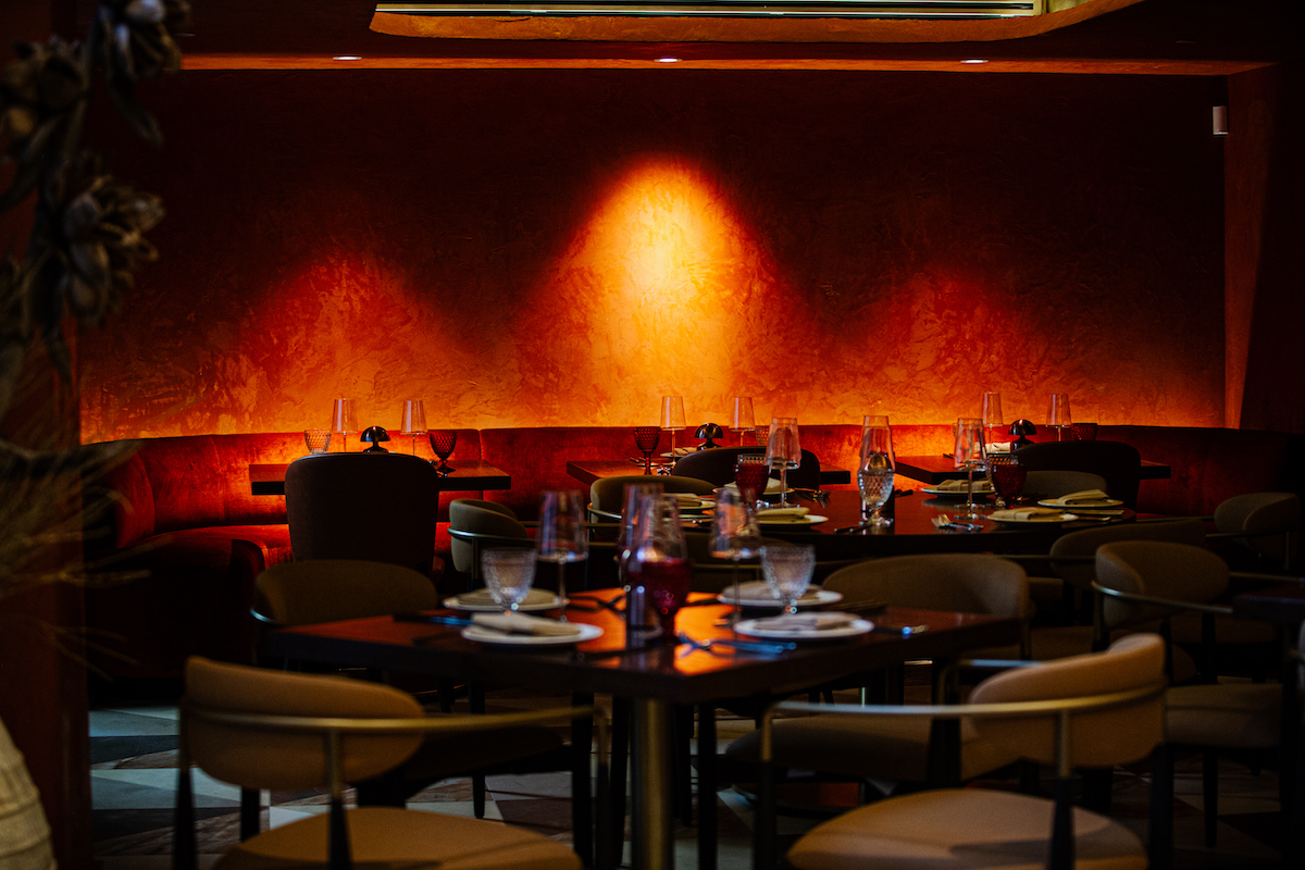 Rust-colored walls, warm lighting, and plush seating set the scene inside Pataaka near Georgia Tech. | Photo by Spark Novus