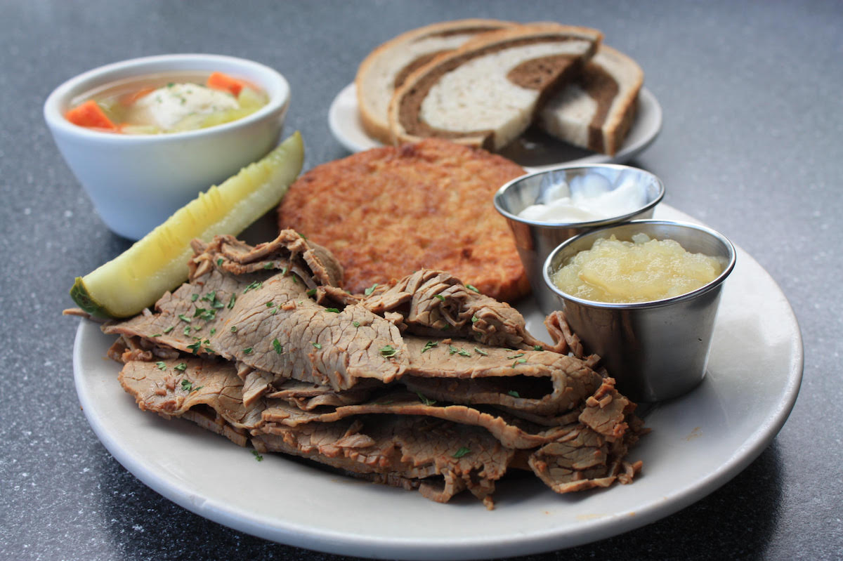 Miracle Mile Deli - DiningOut Miracle Mile Deli marks Rosh Hashanah with a brisket platter served with a potato cake, applesauce, sour cream, matzo ball soup, and rye bread. | Photo by Bite Shot Photography