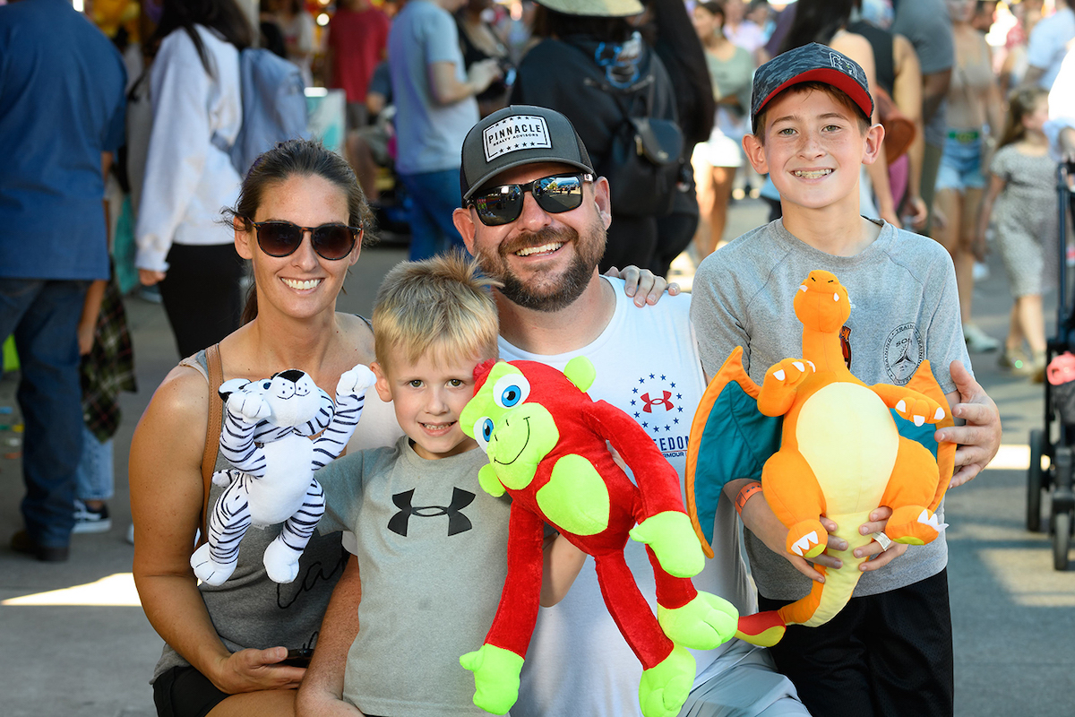 A family shows off their Midway prizes during a day at the State Fair of Texas, where reduced admission prices and additional discounts aim to make the fair more affordable in 2026. | Photo by the State Fair of Texas
