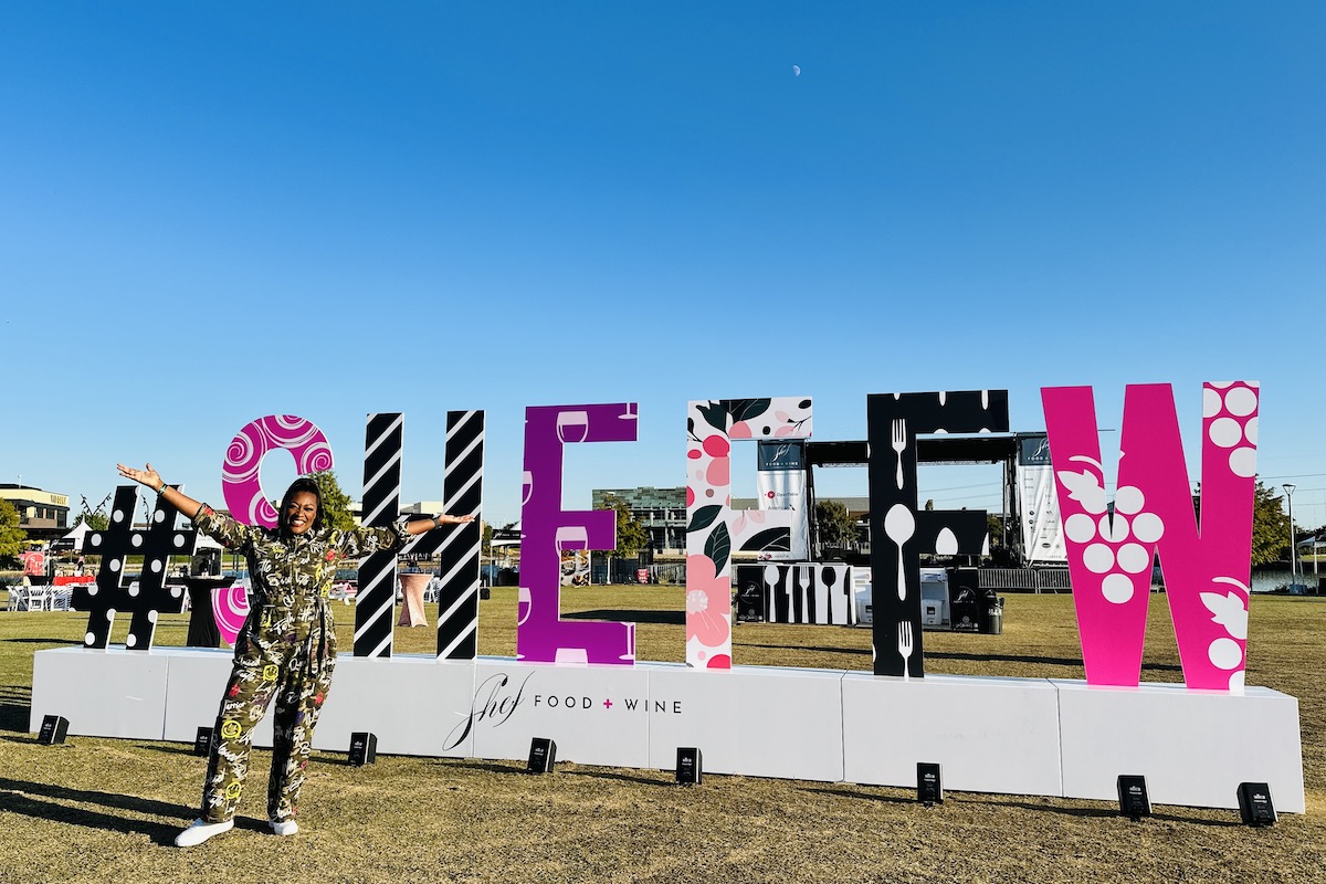 Tiffany Derry poses in front of the Shef Food + Wine Festival sign at EpicCentral in Grand Prairie. | Photo by Shef Food + Wine Festival