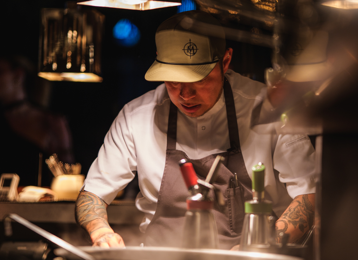 Meridian DAL - DiningOut Chef Eduardo Osorio at work in the kitchen at Meridian, where his live-fire cooking approach drives the Dallas restaurant’s evolving menu. | Photo by The Village